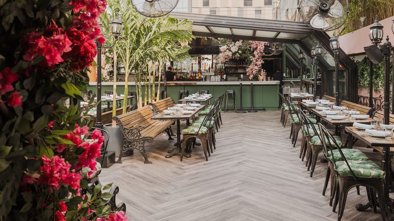 Long tables on the rooftop framed by bougainvillea