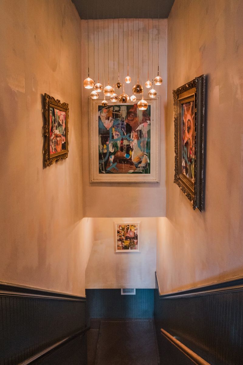 Gallery wall and chandelier on the way up to the roof
